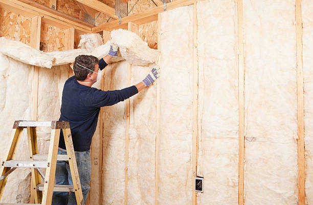 Man installing thermal roof insulation layer using mineral wool panels